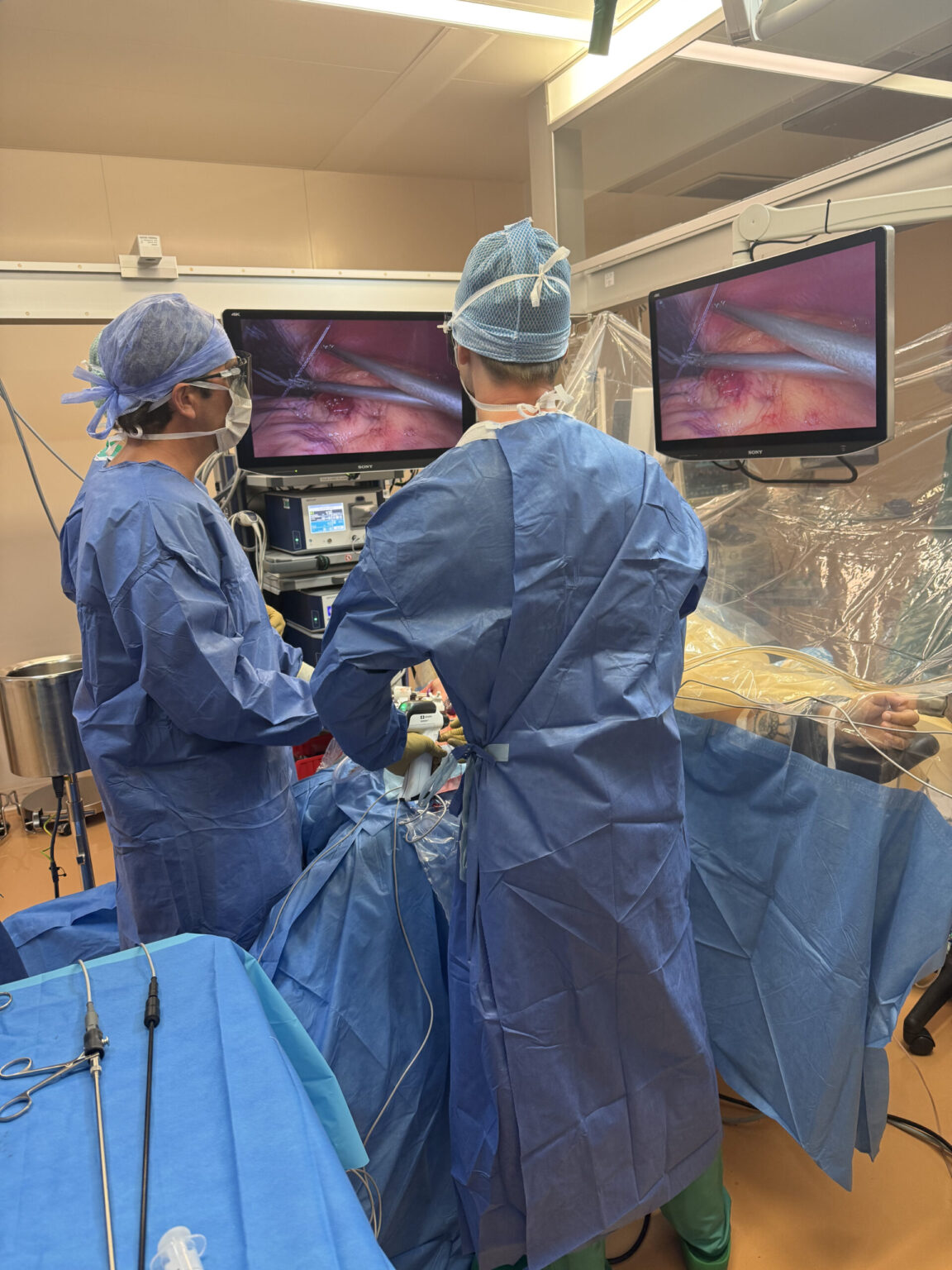 Équipe chirurgicale vue de dos pendant une intervention mini-invasive au bloc opératoire de l’Hôpital de Nyon