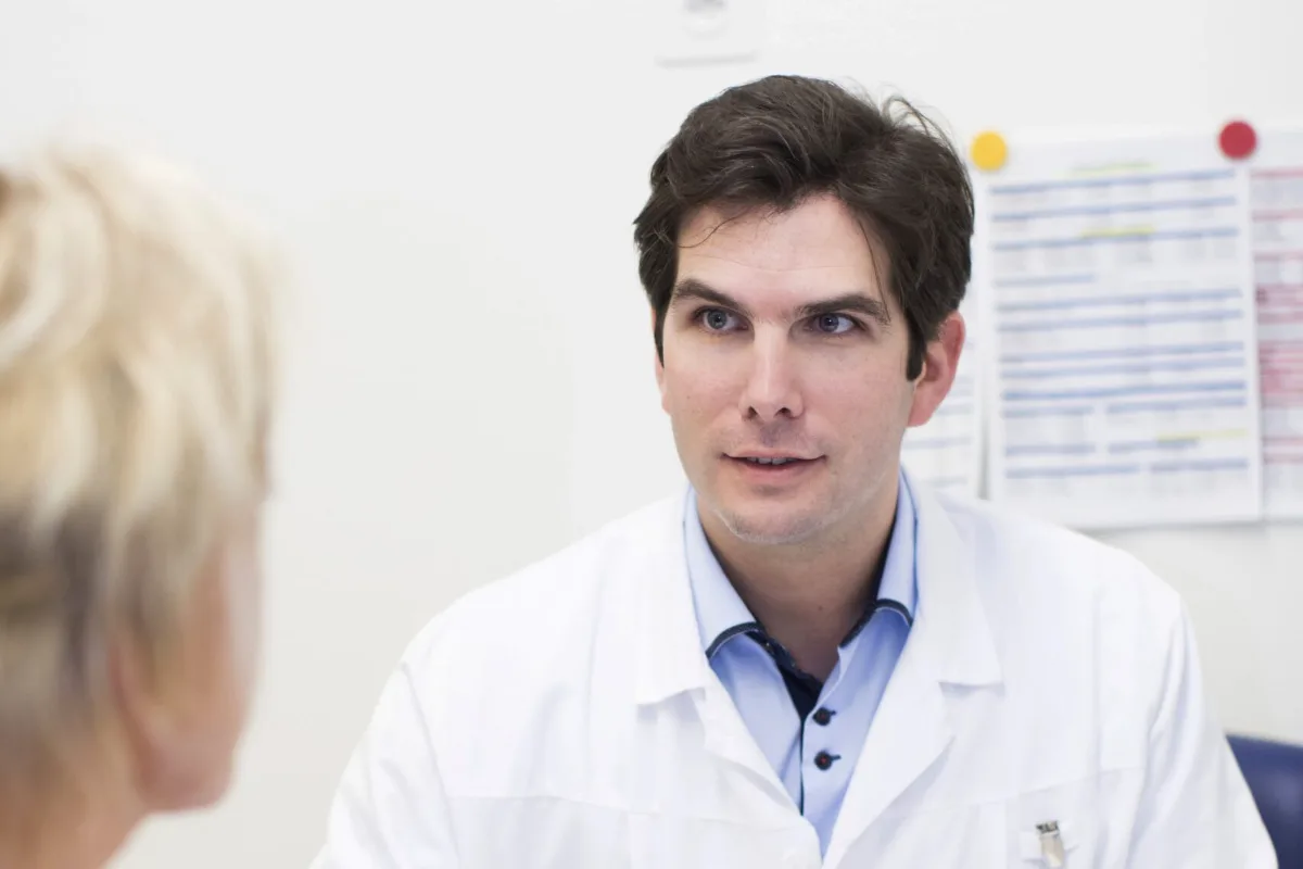 Le Dr Pierre Fournier en consultation, face à une personne vue de dos